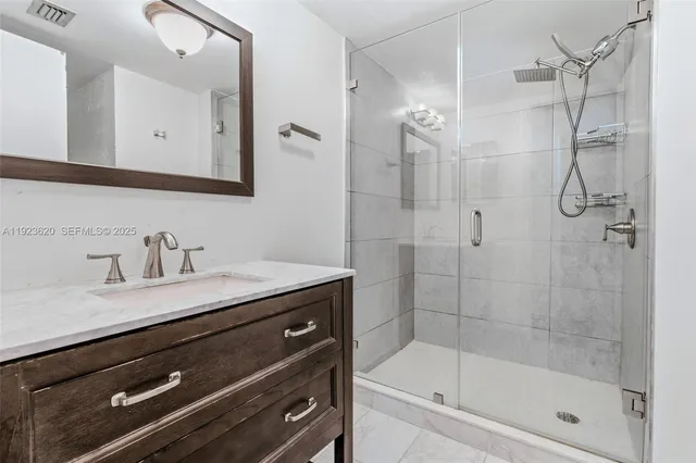 a bathroom with a granite countertop sink a mirror a shower and a bathtub