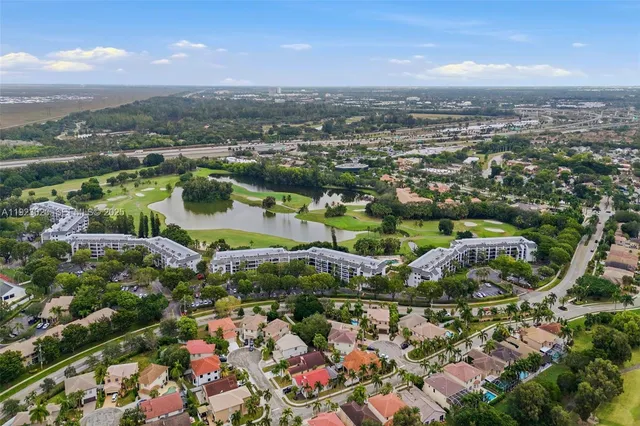 an aerial view of residential houses with outdoor space and trees