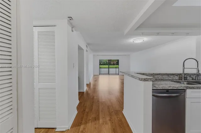 a view of a kitchen cabinets a sink and wooden floor