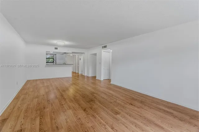 a view of empty room with wooden floor