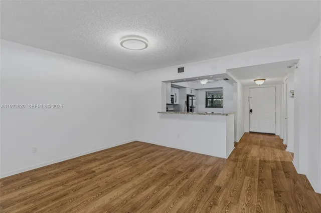 a view of empty room with wooden floor and fireplace