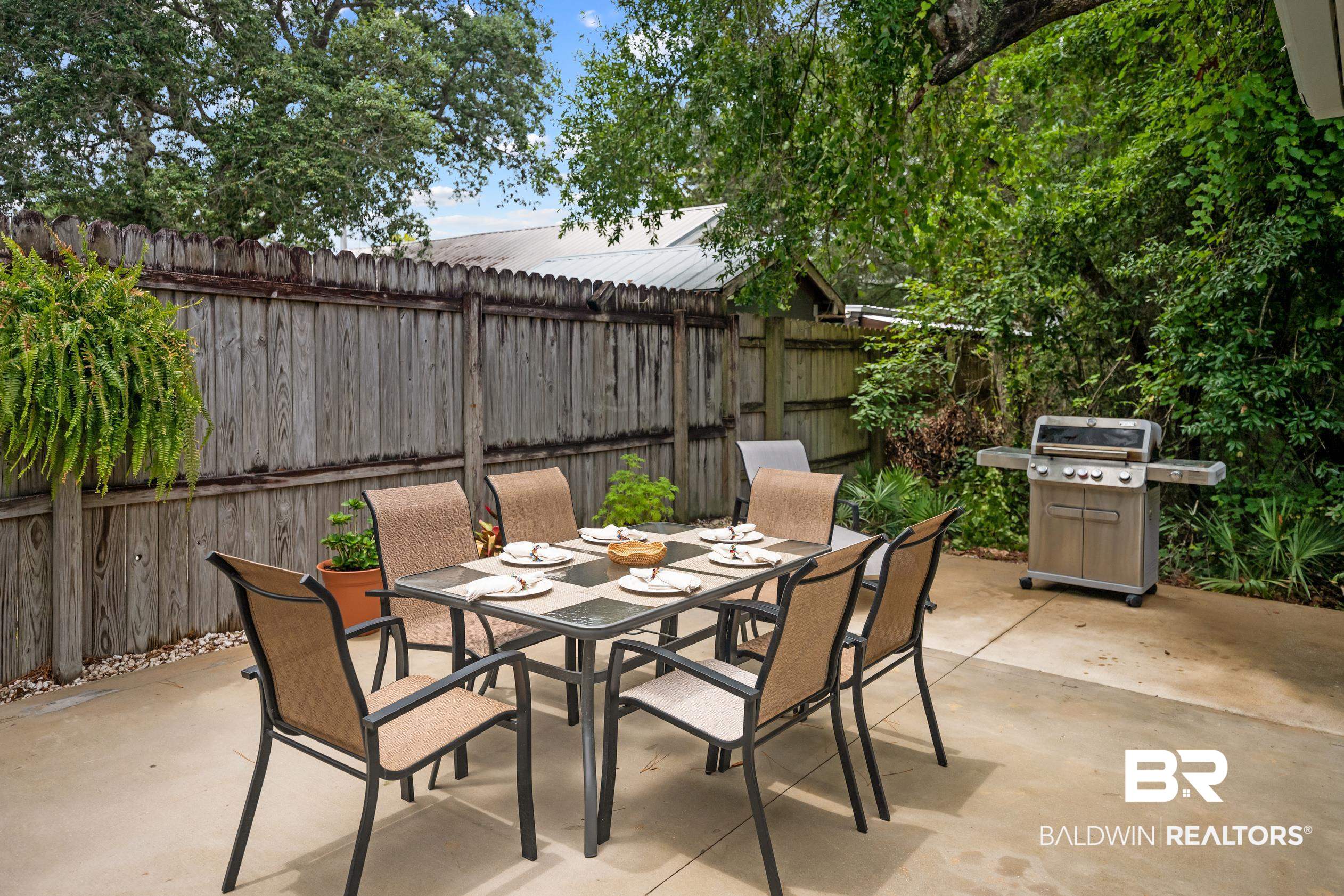 5501 Mobile Avenue Orange Beach, AL 36561 - Photo 24 of 40 Fenced backyard with outdoor dining space, a grill, and a patio