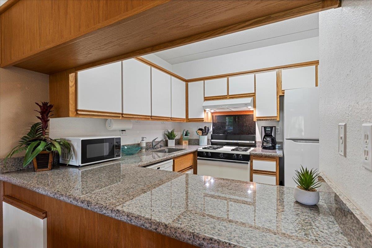 2531 South Kihei Road, Unit C317 Kihei, HI 96753 - Photo 11 of 32 a kitchen with a stove a sink and a microwave