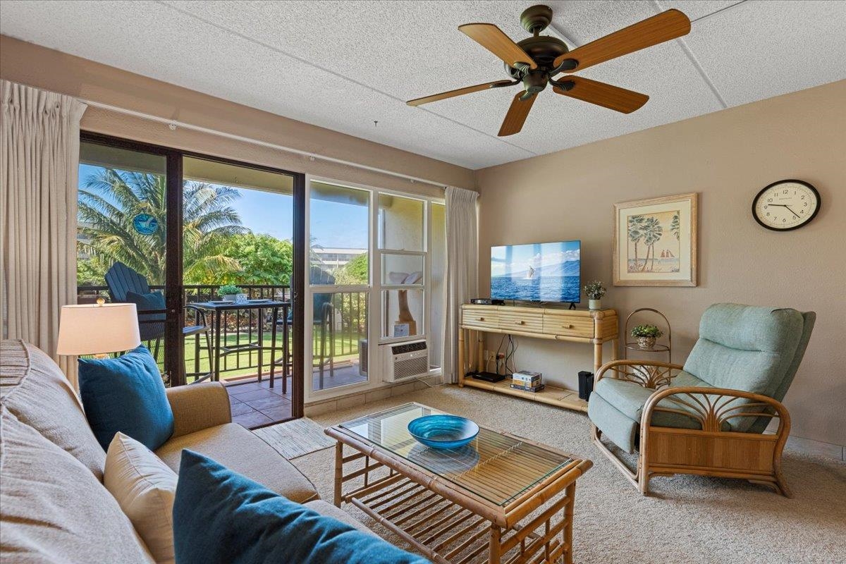 2531 South Kihei Road, Unit C317 Kihei, HI 96753 - Photo 2 of 32 a living room with furniture a flat screen tv and a floor to ceiling window