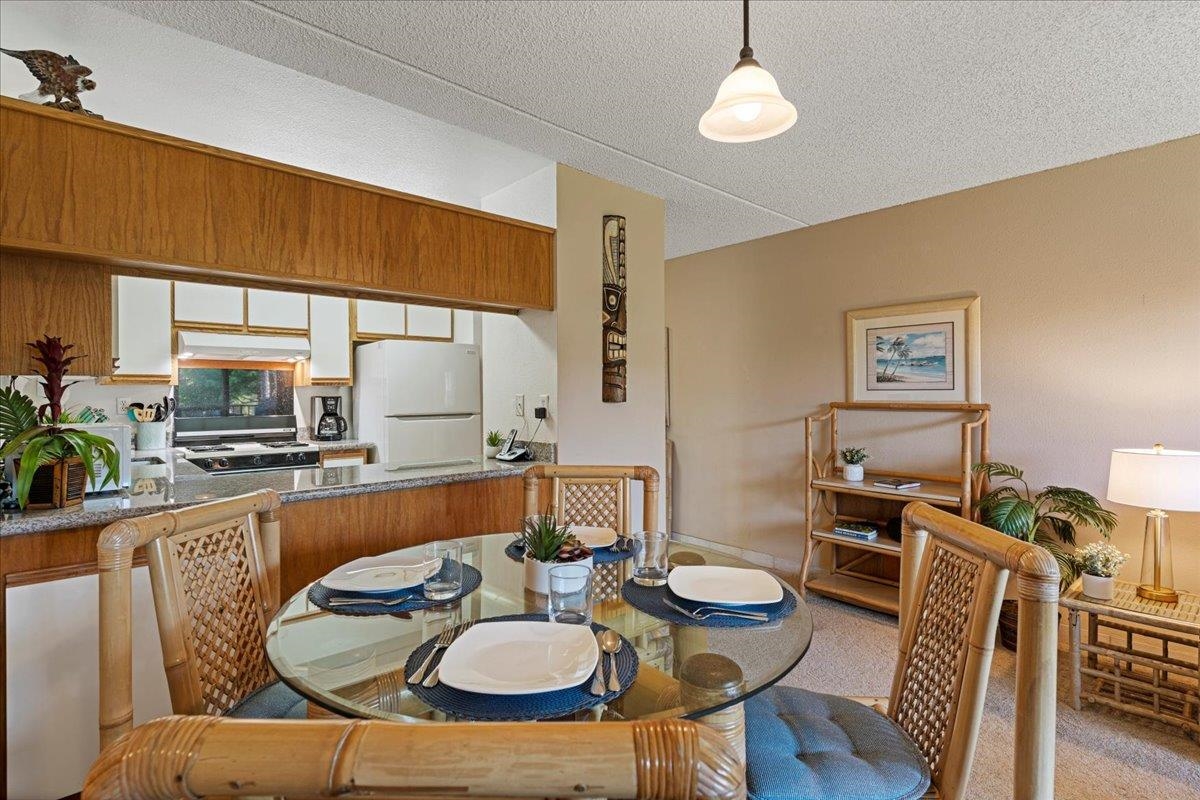 2531 South Kihei Road, Unit C317 Kihei, HI 96753 - Photo 9 of 32 a kitchen with stainless steel appliances kitchen island granite countertop a table and chairs in it