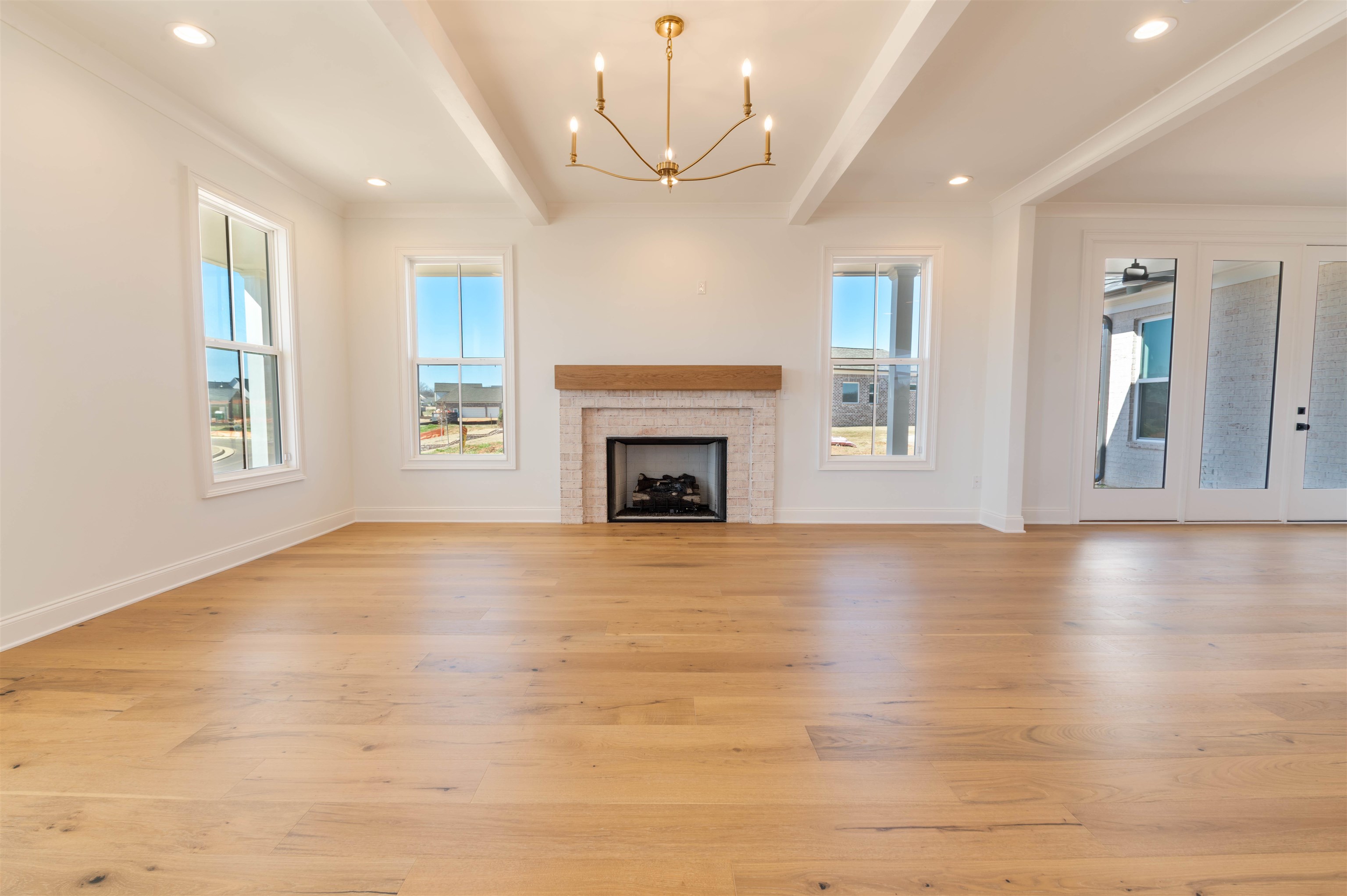30 Rambling Rex Trail Piperton, TN 38017 - Photo 13 of 27 Unfurnished living room with beamed ceiling, a fireplace, light wood-type flooring, and baseboards