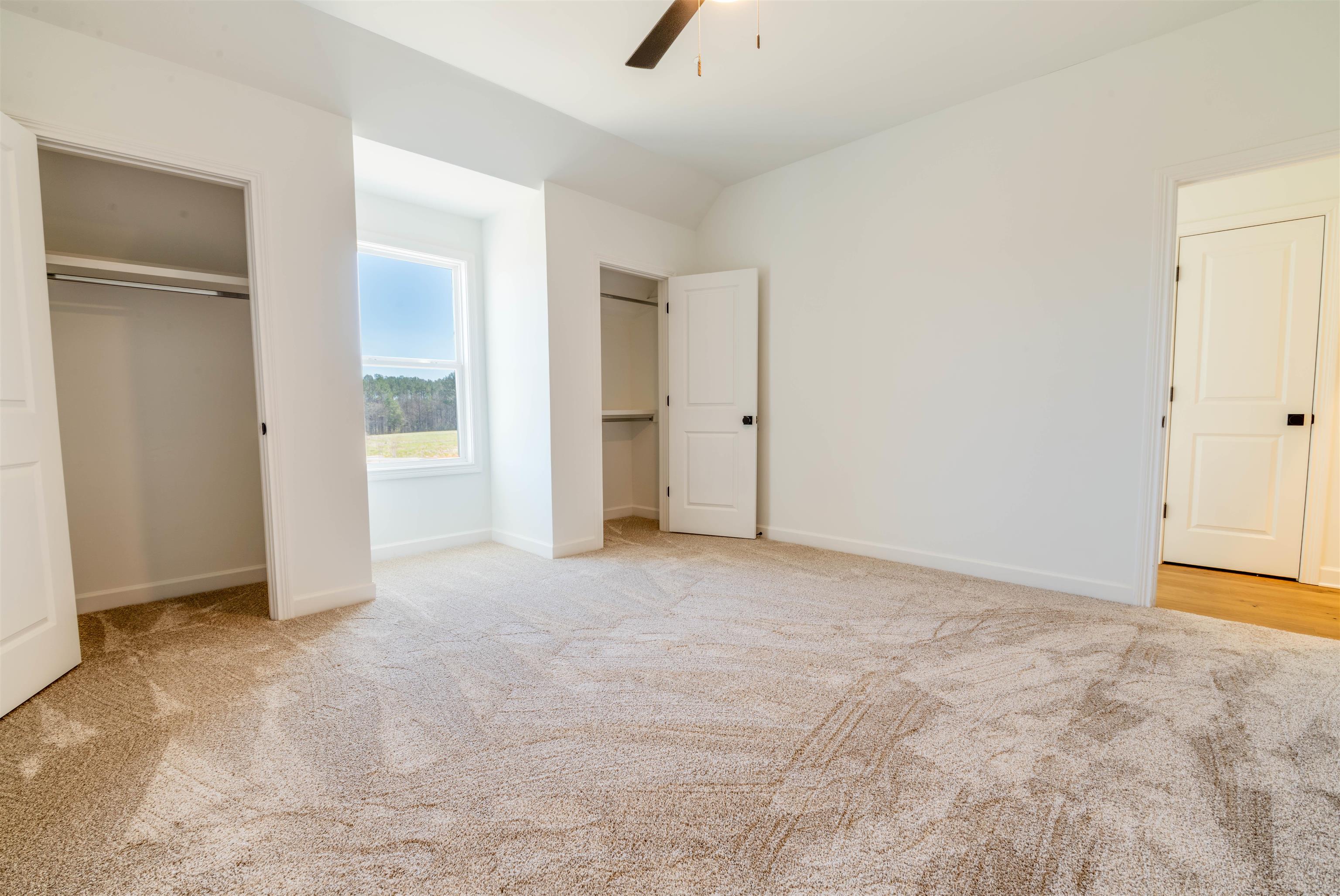 30 Rambling Rex Trail Piperton, TN 38017 - Photo 18 of 27 Unfurnished bedroom with baseboards, carpet floors, multiple closets, and vaulted ceiling