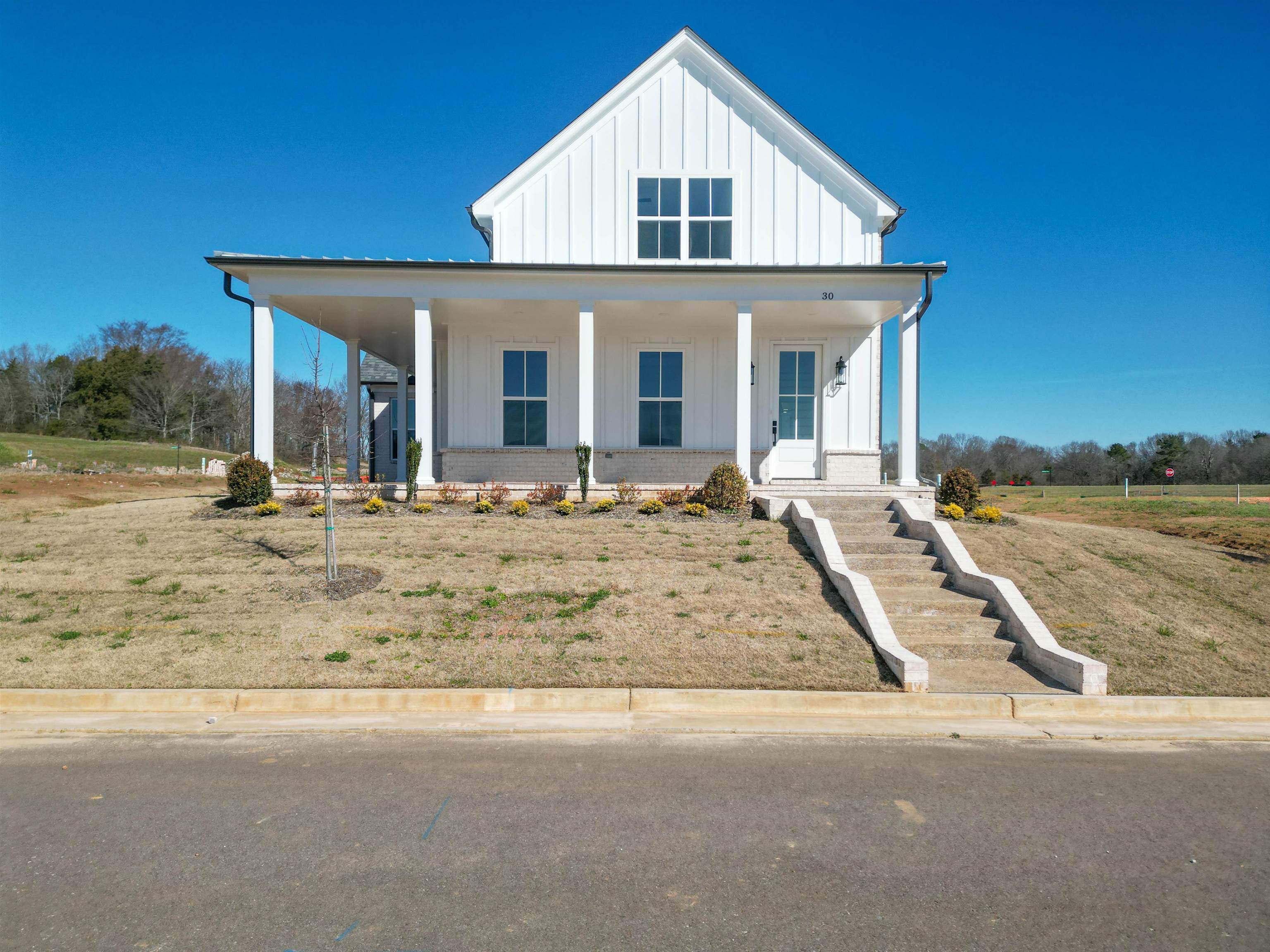 30 Rambling Rex Trail Piperton, TN 38017 - Photo 2 of 27 View of front facade featuring brick siding, covered porch, and board and batten siding