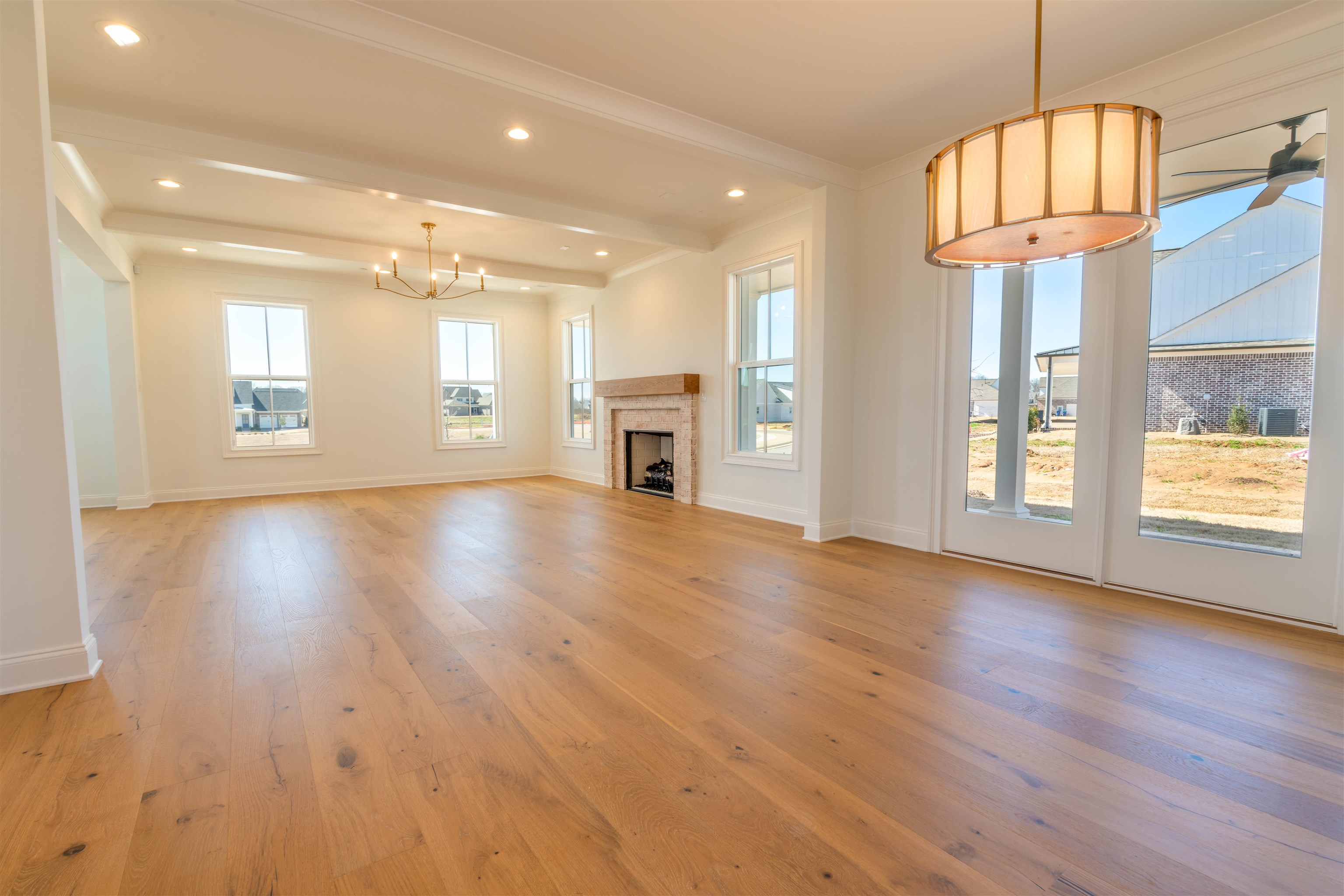 30 Rambling Rex Trail Piperton, TN 38017 - Photo 7 of 27 Unfurnished living room featuring beamed ceiling, baseboards, a fireplace, and light wood finished floors