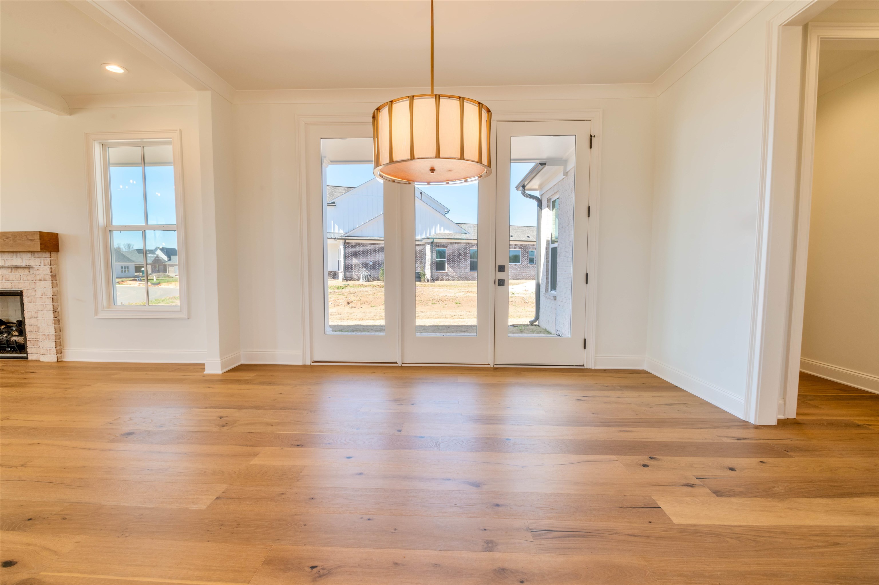 30 Rambling Rex Trail Piperton, TN 38017 - Photo 8 of 27 Interior space with plenty of natural light, light wood-style floors, a stone fireplace, and crown molding