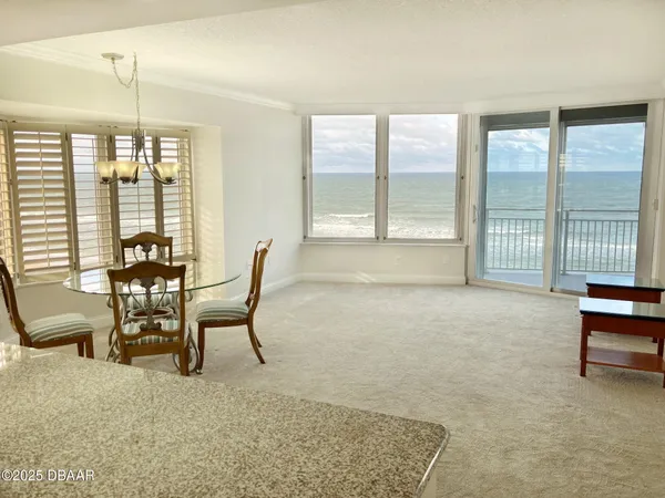 a dining room with furniture and a large window