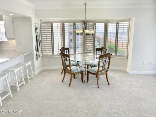 a kitchen with stainless steel appliances granite countertop a table chairs stove microwave and cabinets