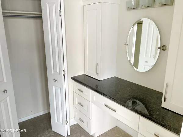 a bathroom with a granite countertop bathtub shower sink vanity and toilet