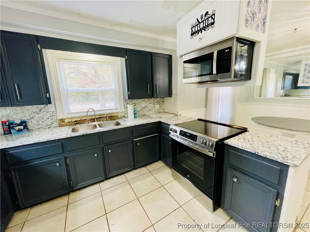 405 South Austin Street Maxton, NC 28364 - Photo 23 of 41 a kitchen with stainless steel appliances granite countertop a sink stove and microwave