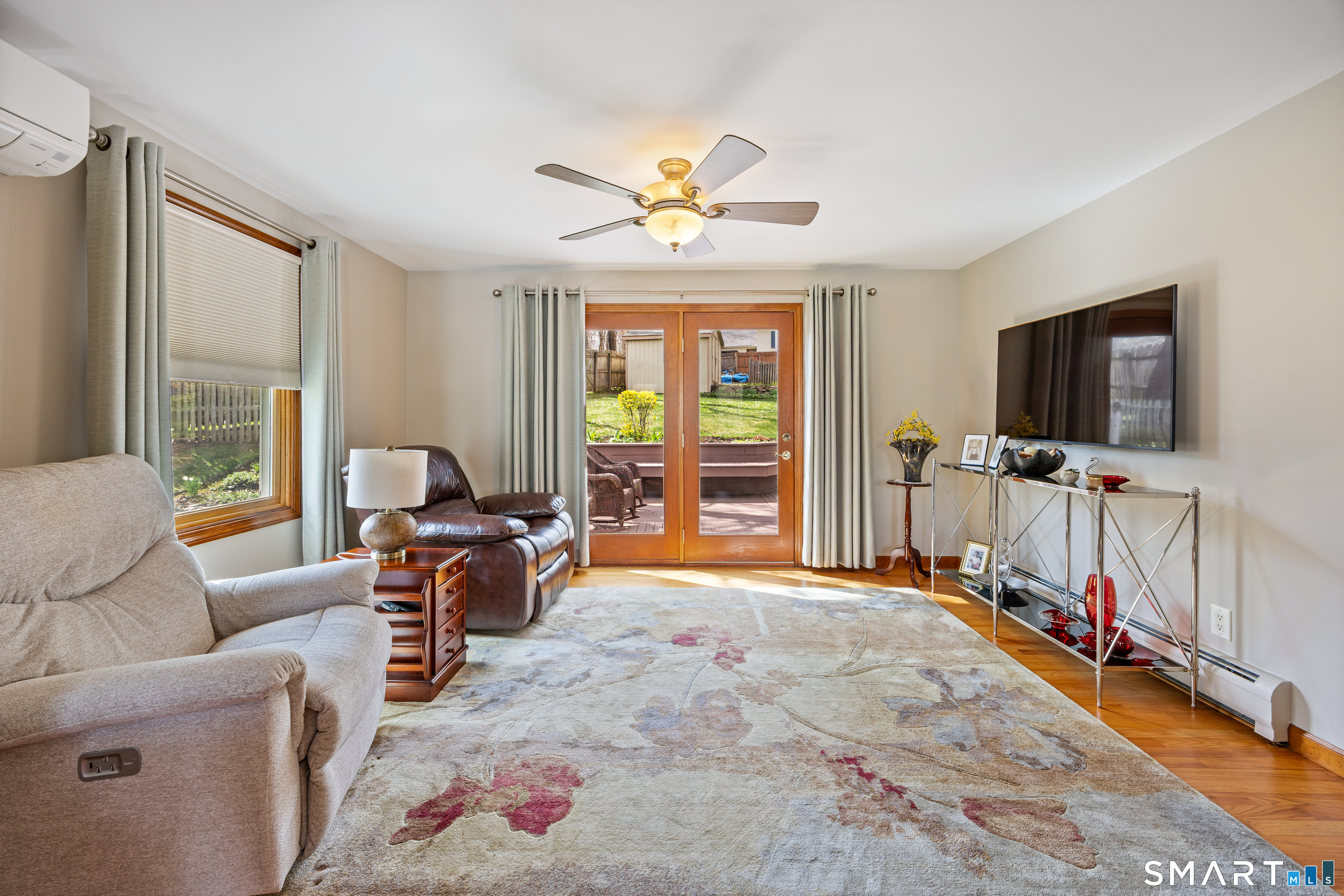 42 Chimney Sweep Road Wallingford, CT 06492 - Photo 16 of 40 a living room with furniture a flat screen tv and a floor to ceiling window