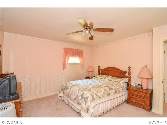3920 Huntwood Road Richmond, VA 23235 - Photo 8 of 20 a bedroom with a bed ceiling fan and a wooden floor