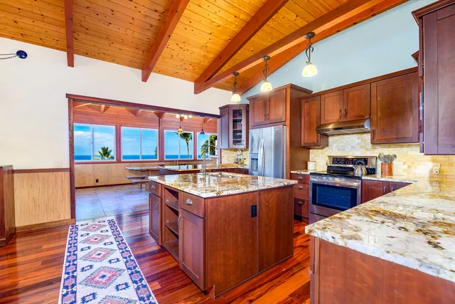 a kitchen with kitchen island a stove a sink and a refrigerator