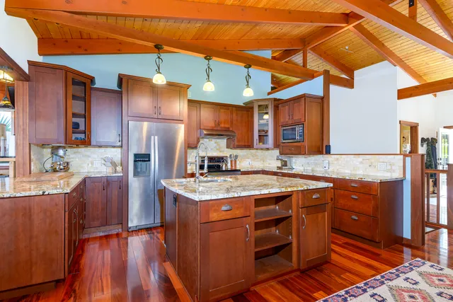 a kitchen with stainless steel appliances granite countertop a sink and wooden cabinets
