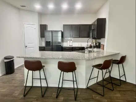 a kitchen with granite countertop a sink cabinets and stainless steel appliances
