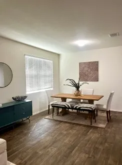 a kitchen with stainless steel appliances granite countertop a dining table chairs and a refrigerator