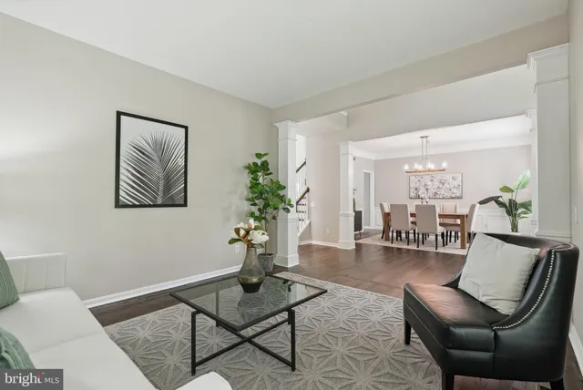 a kitchen with stainless steel appliances kitchen island granite countertop a sink dishwasher stove and white cabinets with wooden floor