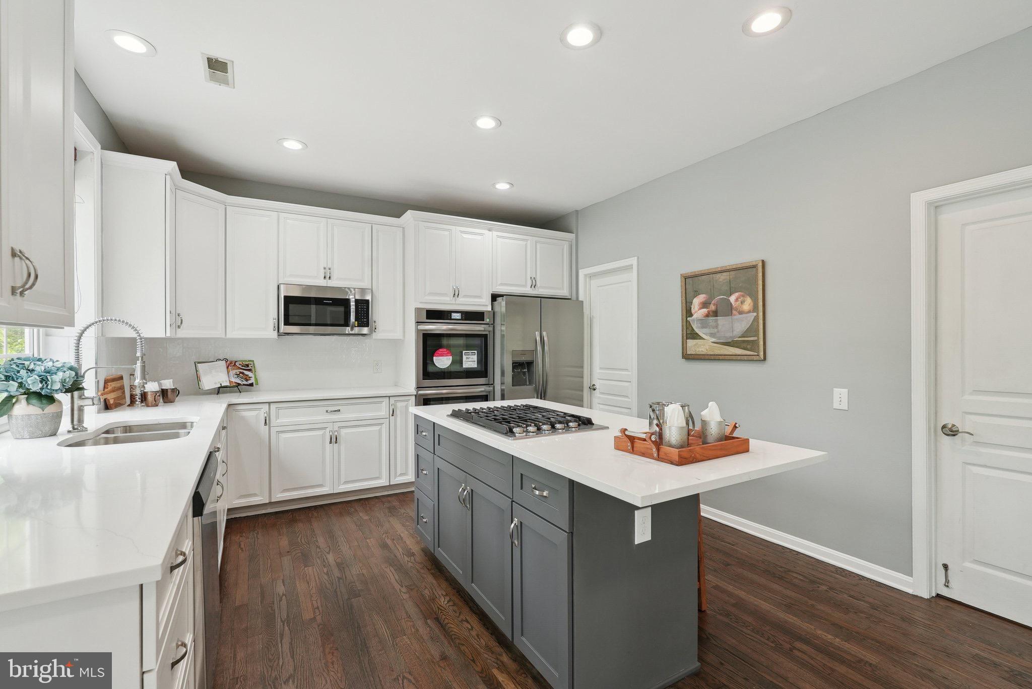 51 Knickerbocker Lane Malvern, PA 19355 - Photo 19 of 57 a kitchen with stainless steel appliances kitchen island granite countertop a sink dishwasher stove and white cabinets with wooden floor