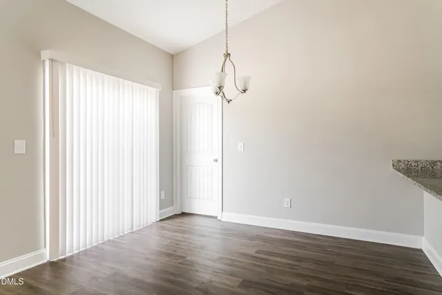 a view of a room with wooden floor and white walls