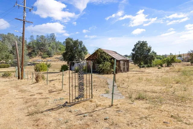 a view of a yard with wooden fence