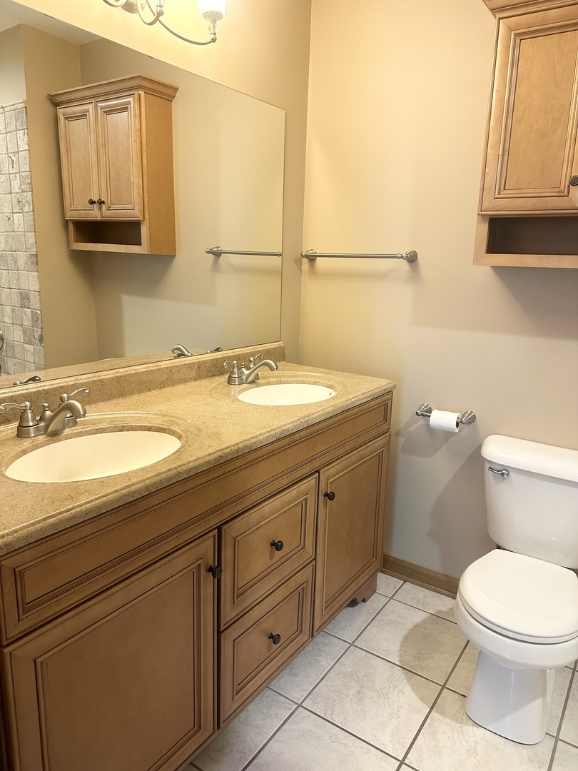 516 Whelan Street Lockport, IL 60441 - Photo 18 of 27 a bathroom with a granite countertop toilet sink and mirror