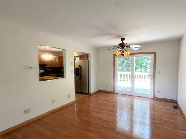 a view of an empty room with window and wooden floor