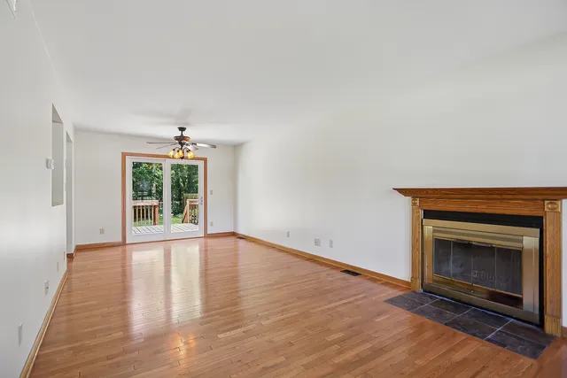a view of an empty room with a fireplace and a window