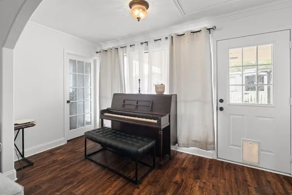 a view of a room with wooden floor a ceiling fan and windows