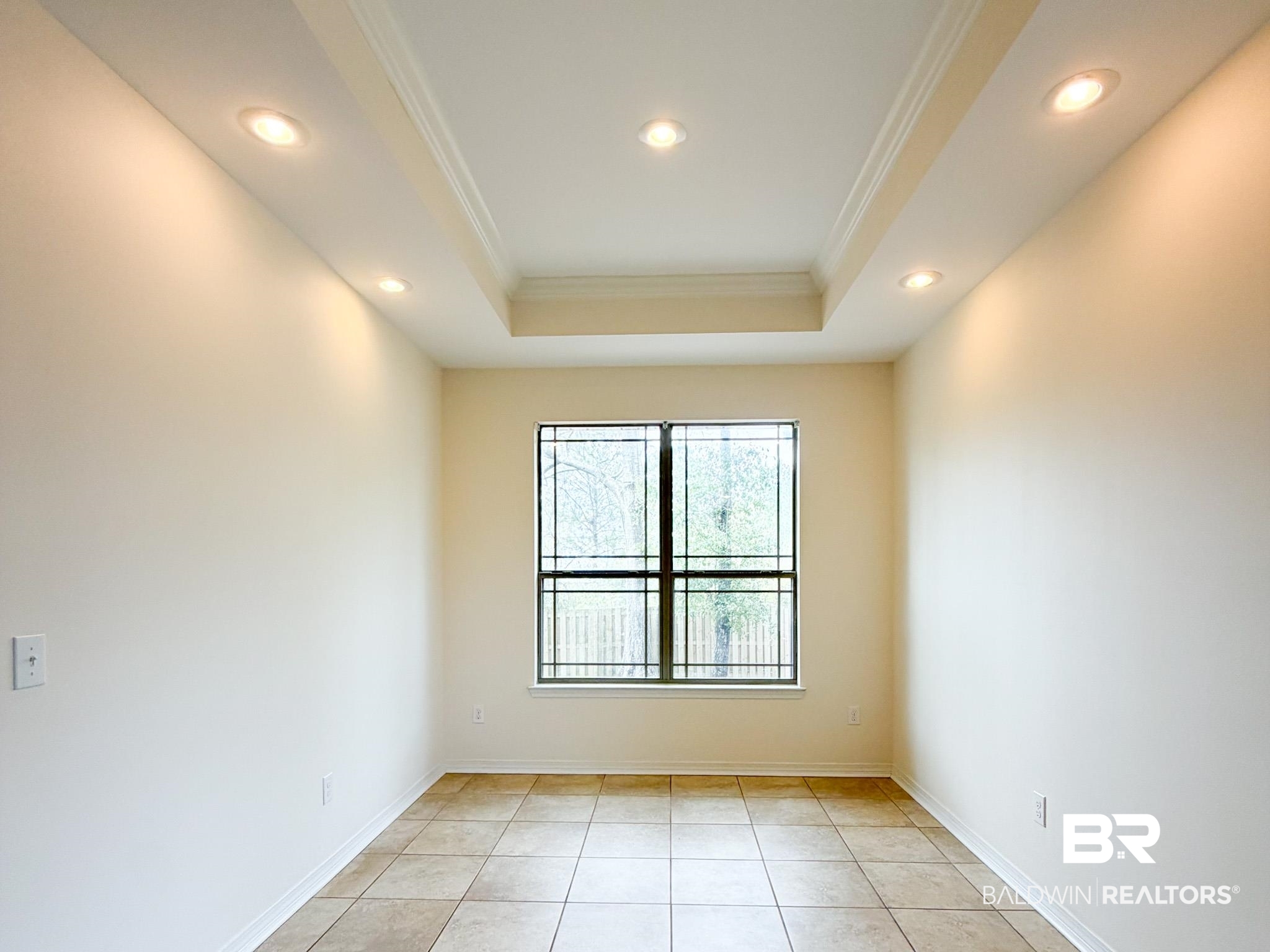7332 Raintree Lane Gulf Shores, AL 36542 - Photo 5 of 21 Unfurnished room with crown molding, a raised ceiling, recessed lighting, and light tile patterned floors