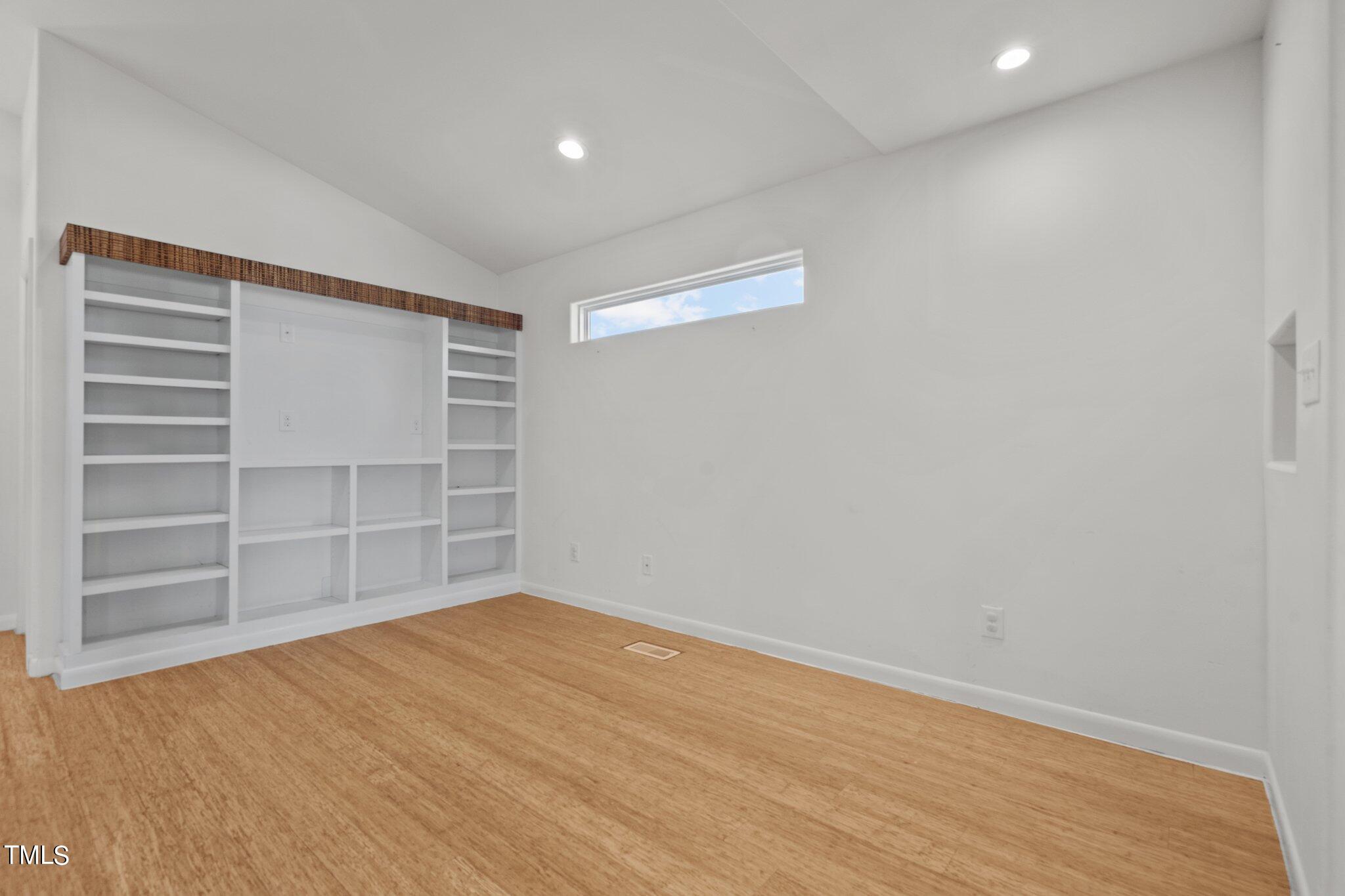 1427 East Lane Street Raleigh, NC 27610 - Photo 8 of 53 a view of an empty room with a window and wooden floor