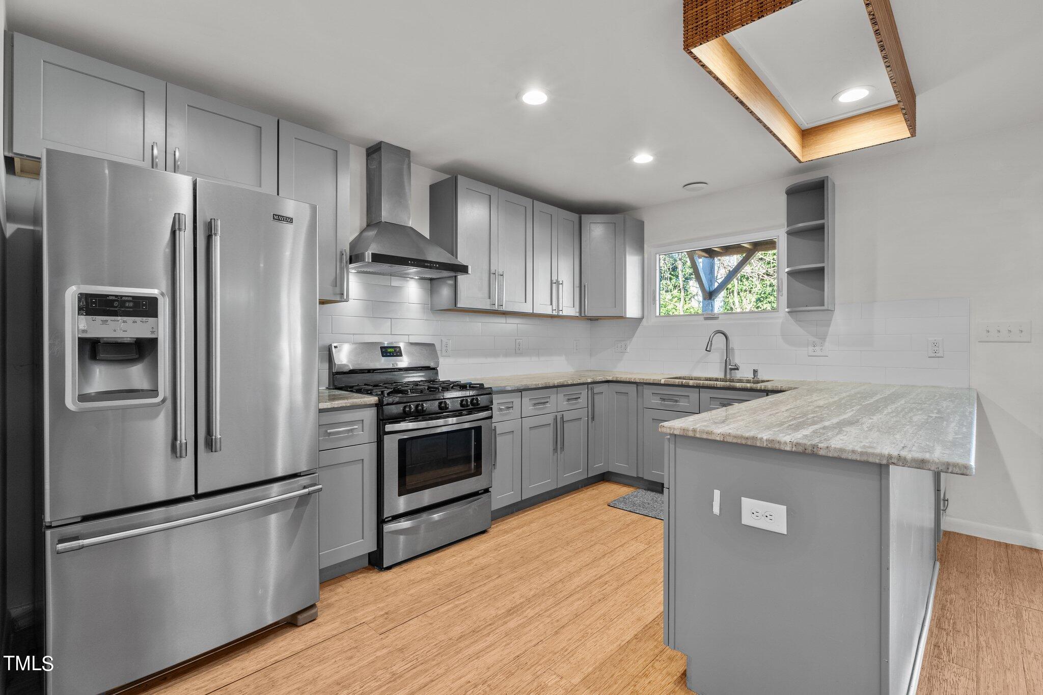 1427 East Lane Street Raleigh, NC 27610 - Photo 9 of 53 a kitchen with stainless steel appliances granite countertop a refrigerator a sink a stove and a refrigerator
