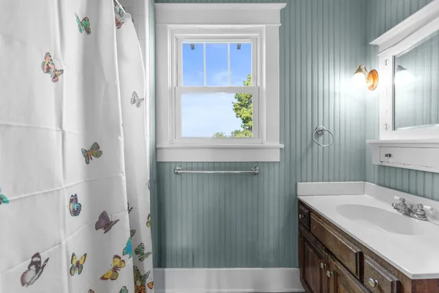 a bedroom with a bed and a dresser next to a window