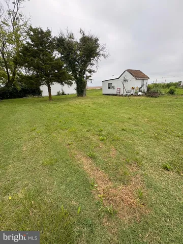 a view of a field of grass and trees