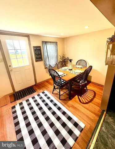 a living room with a black white checkered floor with a gaming machine and dining table