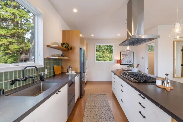 a kitchen with stove a sink and cabinets