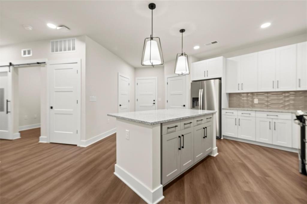 2648 Sandy Plains Road, Unit 420 Marietta, GA 30062 - Photo 4 of 37 a kitchen with white cabinets stainless steel appliances and wooden floor