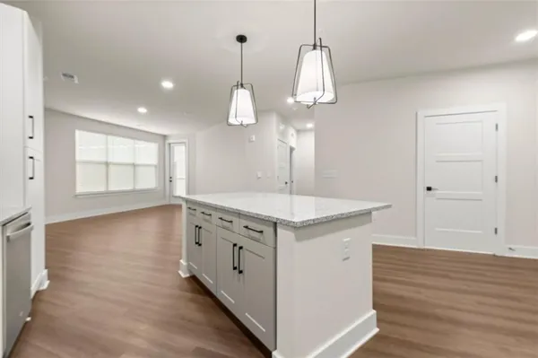 a kitchen with stainless steel appliances granite countertop a sink a stove and a wooden floor
