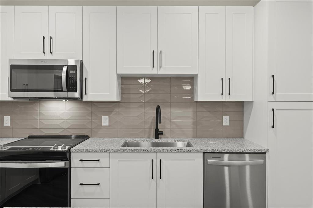 2648 Sandy Plains Road, Unit 420 Marietta, GA 30062 - Photo 6 of 37 a kitchen with granite countertop white cabinets and a stove top oven