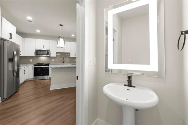 a kitchen with a sink stainless steel appliances and white cabinets