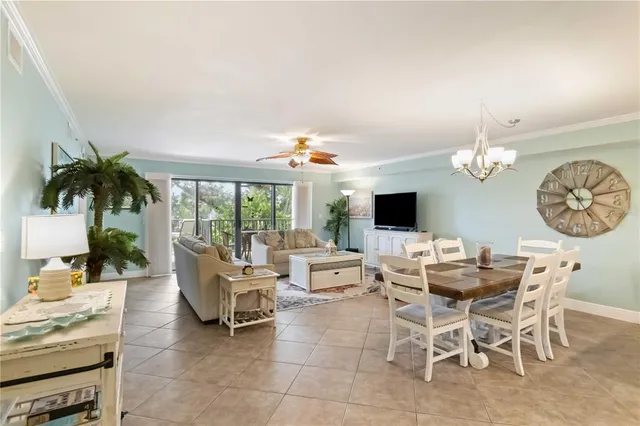 a dining room filled chandelier and kitchen view