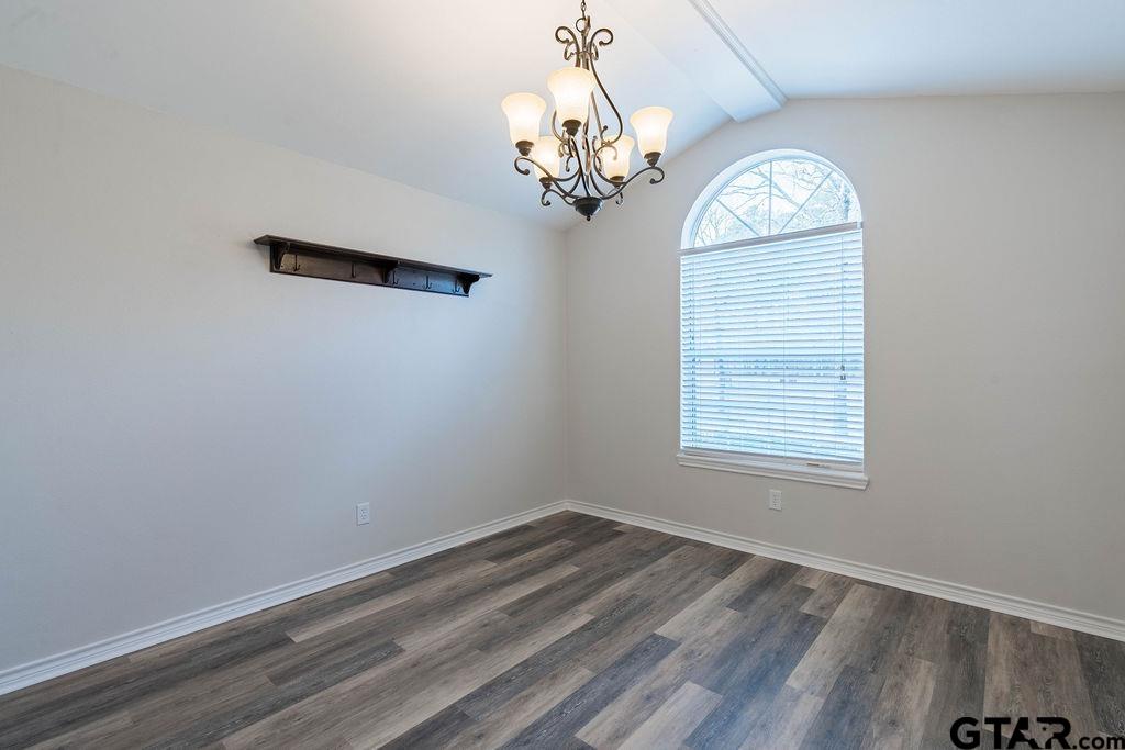 360 Anderson County Road Palestine, TX 75803 - Photo 15 of 41 an empty room with wooden floor chandelier and windows