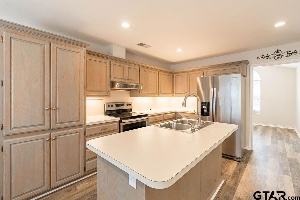 360 Anderson County Road Palestine, TX 75803 - Photo 17 of 41 a kitchen with stainless steel appliances granite countertop a refrigerator a stove and white cabinets with wooden floor