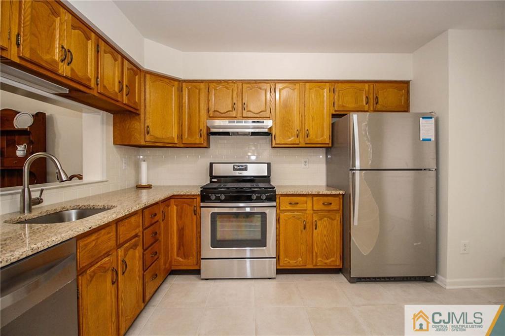 1705 Timber Oaks Road, Unit 1705 Edison, NJ 08820 - Photo 12 of 25 a kitchen with stainless steel appliances granite countertop a refrigerator and a sink