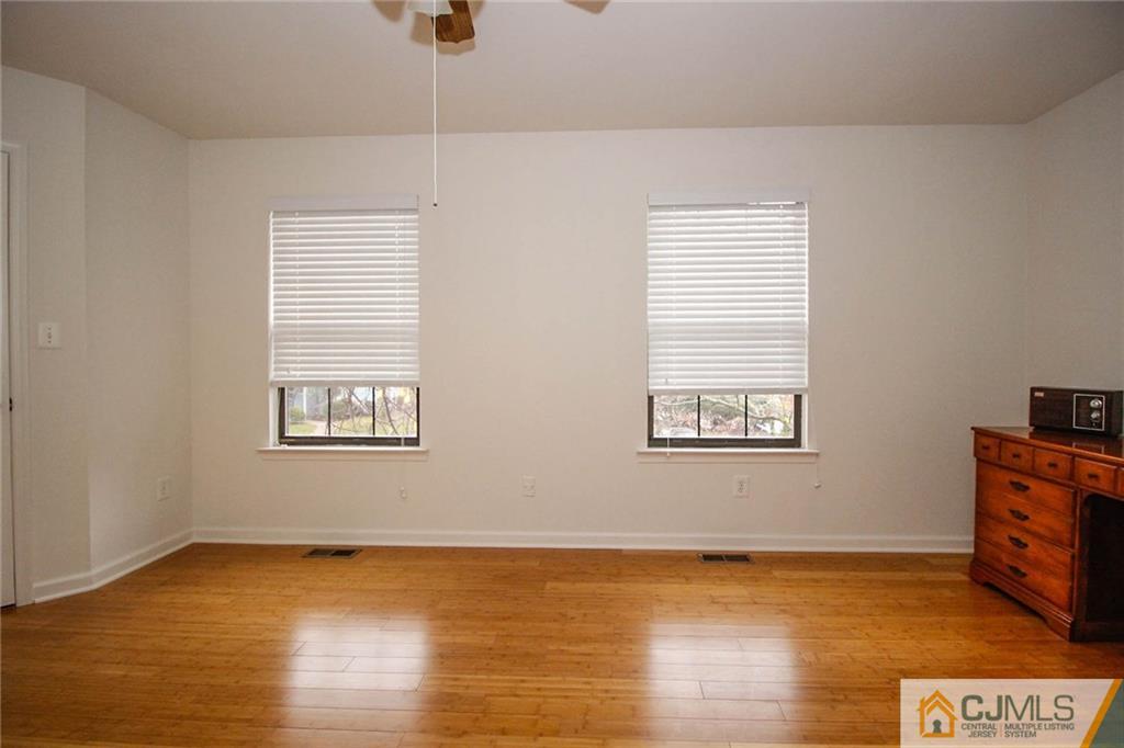 1705 Timber Oaks Road, Unit 1705 Edison, NJ 08820 - Photo 22 of 25 a view of an empty room with wooden floor and a window