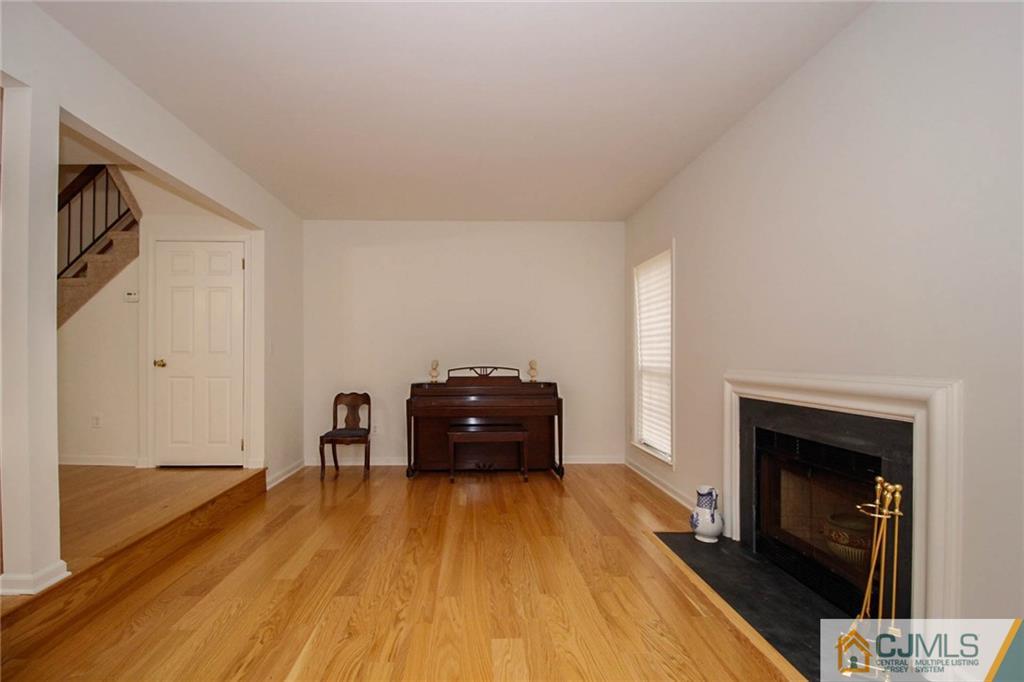1705 Timber Oaks Road, Unit 1705 Edison, NJ 08820 - Photo 8 of 25 a living room with a fireplace and wooden floor