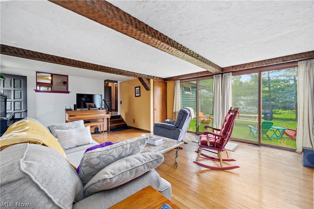 324 Erie Road Vermilion, OH 44089 - Photo 24 of 36 Living room featuring light hardwood / wood-style floors, beamed ceiling, and a textured ceiling